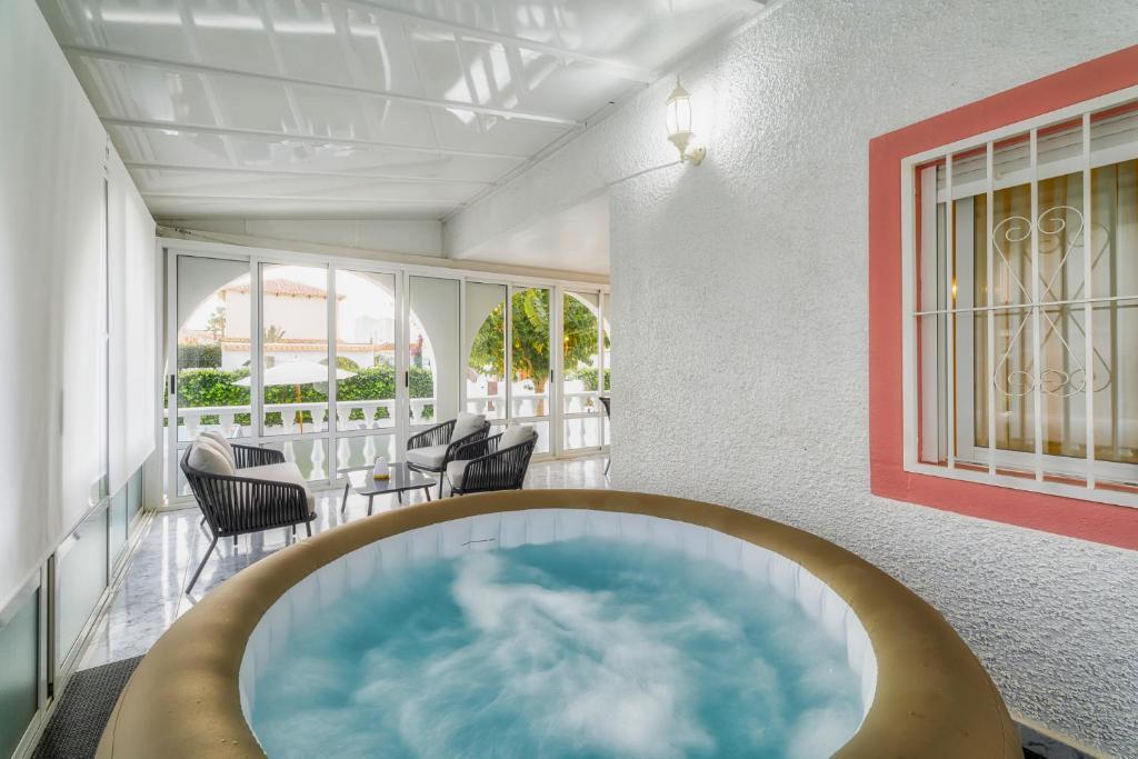 wanna z hydromasażem na środku pokoju z krzesłami w obiekcie VILLA MARIE Estancia Premium en el MAR MENOR con Jacuzzi Climatizado w mieście Los Narejos