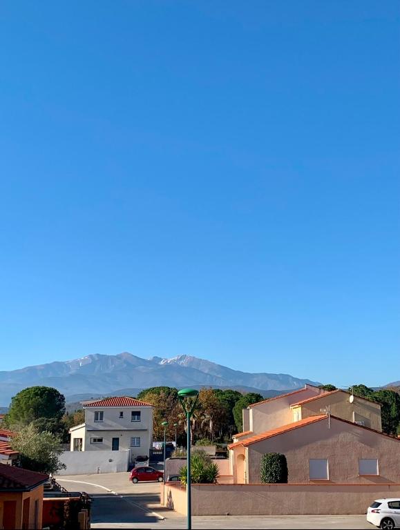 - une vue sur une ville avec des montagnes en arrière-plan dans l'établissement Appartement T2 vue sur le Canigou, à Saint-Jean-Pla-de-Corts