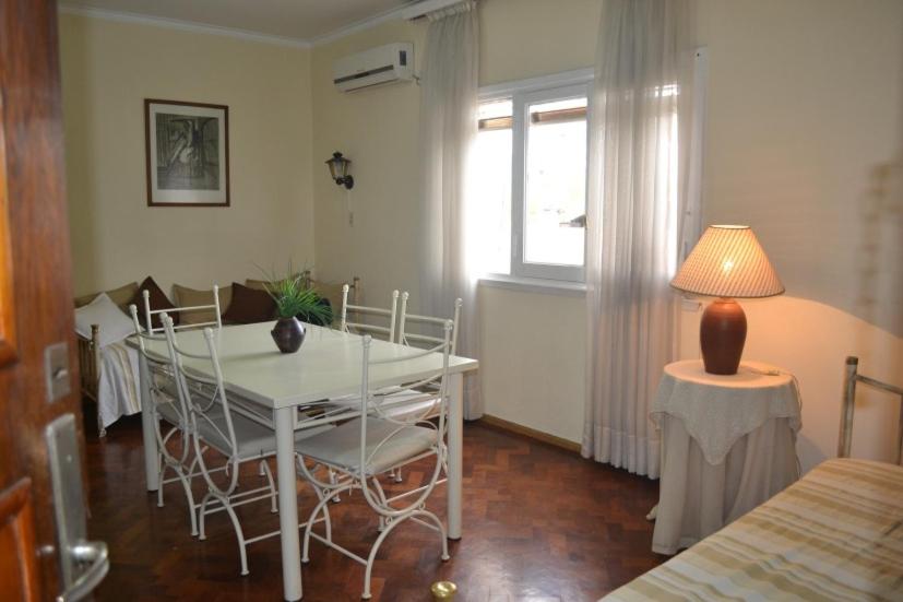 comedor con mesa, sillas y ventana en Mendoza Centrico Departamento Amoblado en Mendoza