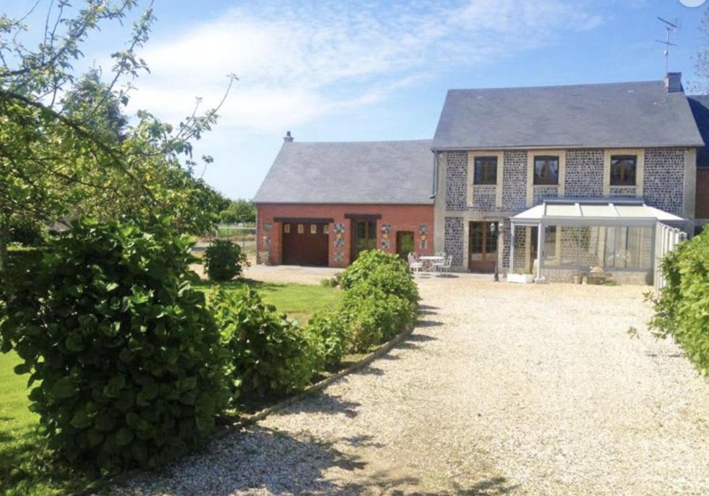 une grande maison en briques avec une allée en face de celle-ci dans l'établissement La Vague, à Saint-Jouin-Bruneval