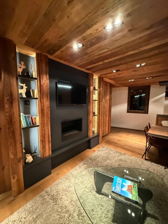 un salon avec une télévision à écran plat et un canapé dans l'établissement Apartement RDJ CŒUR DE MEGEVE, à Megève