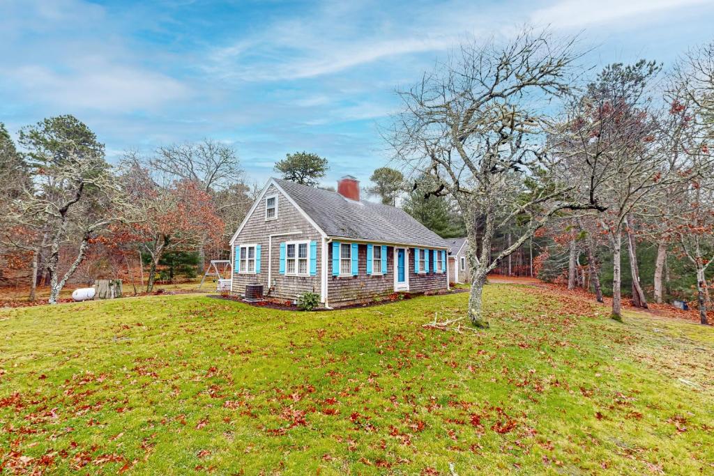 una casa en un campo de hierba con un árbol en Great White Cape Escape, en Orleans
