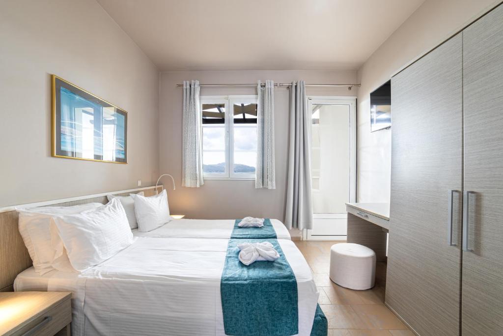a bedroom with a bed with a blue blanket on it at Haraki Village in Haraki