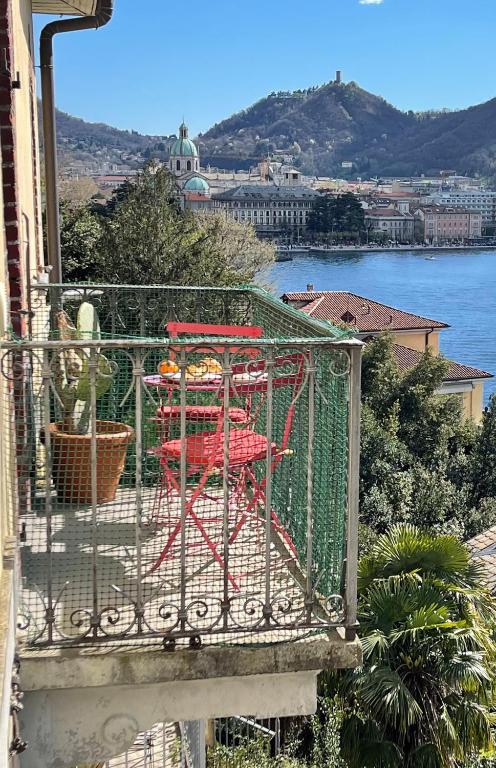 a red table and chair on a balcony overlooking the water at Lake Front View on Viale GENO in Como