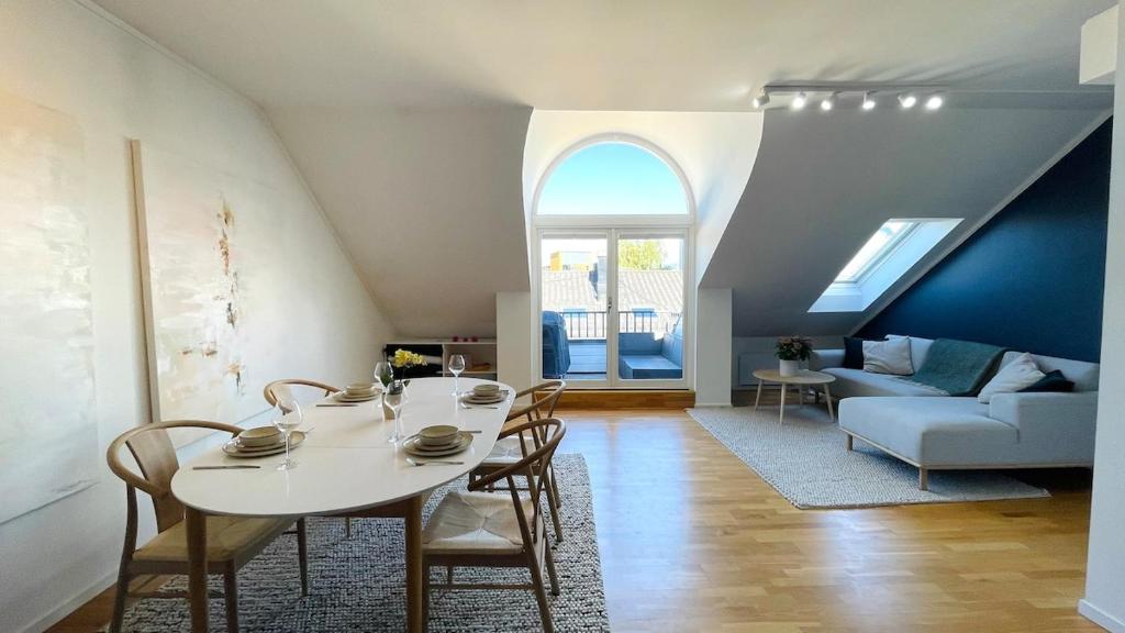 a living room with a white table and chairs at Penthouse apartment balcony,parking and 2 bedrooms in Oslo
