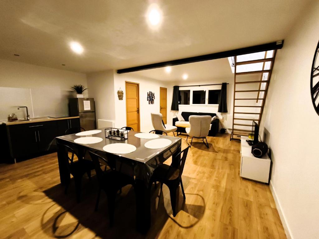 a room with a dining table and a living room at Gite des Plantis in Senneville-sur-Fécamp