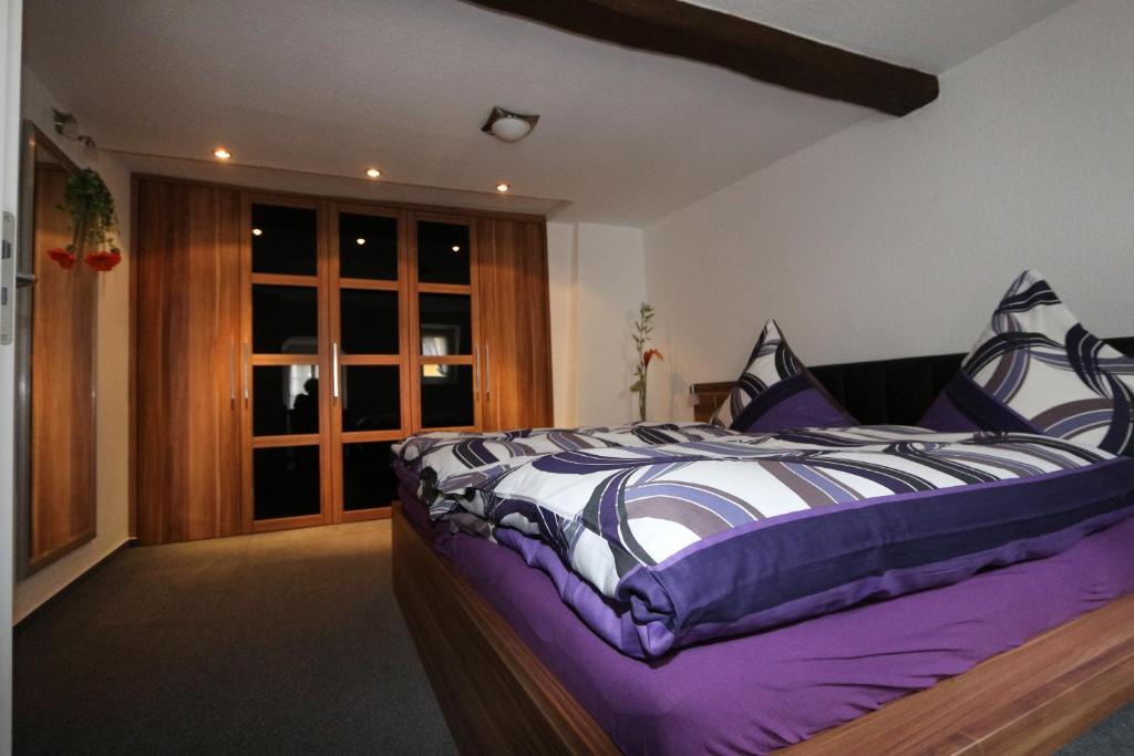 sypialnia z łóżkiem z fioletowo-białą kołdrą w obiekcie Ferienhaus DaVinci w mieście Zell an der Mosel