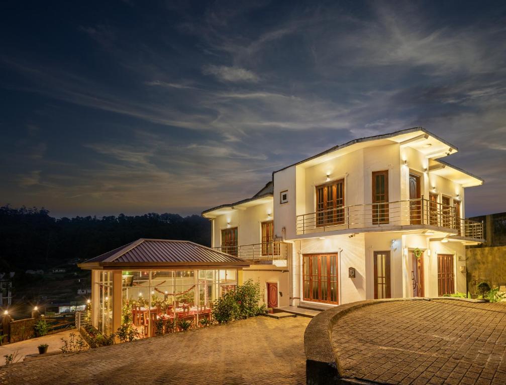 una gran casa blanca por la noche con entrada en Villa Grand Mellow, en Nuwara Eliya
