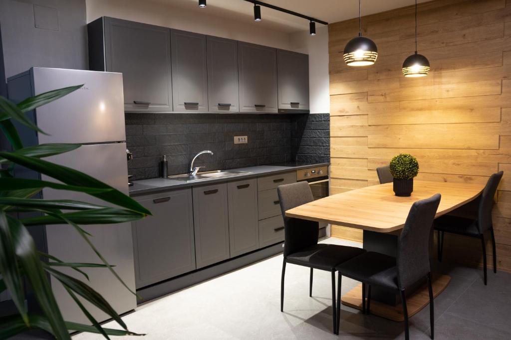 a kitchen with a wooden table and a refrigerator at Zenith - Alpine Retreat in Zărneşti