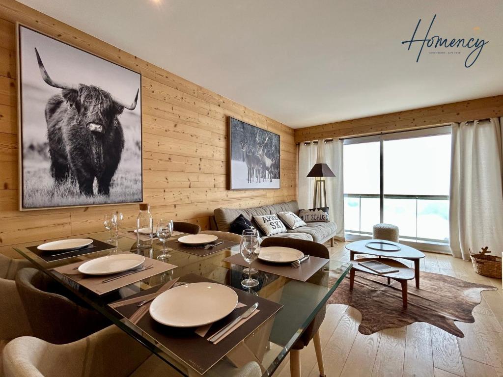 a living room with a table with a bull on the wall at Homency - Residence Signal C32 in L'Alpe-d'Huez