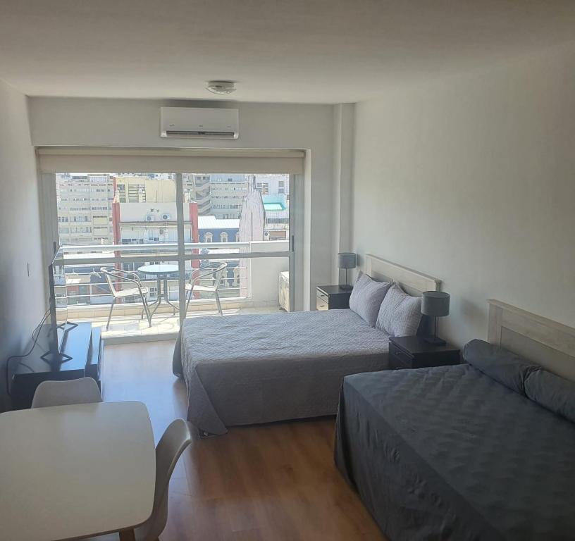une chambre d'hôtel avec deux lits et un balcon dans l'établissement Recoleta a 5 cuadras de El Ateneo, à Buenos Aires