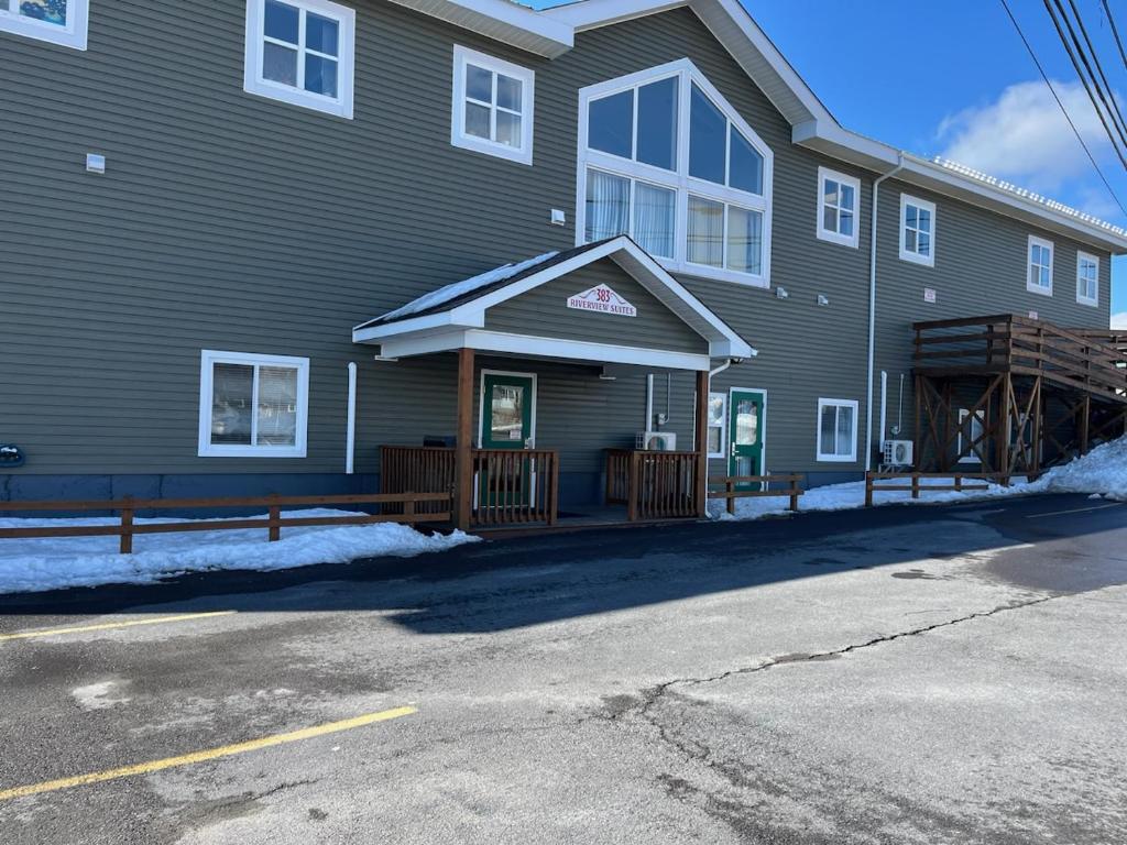 una casa grande con un porche enfrente en Riverview Suites, en Clarenville