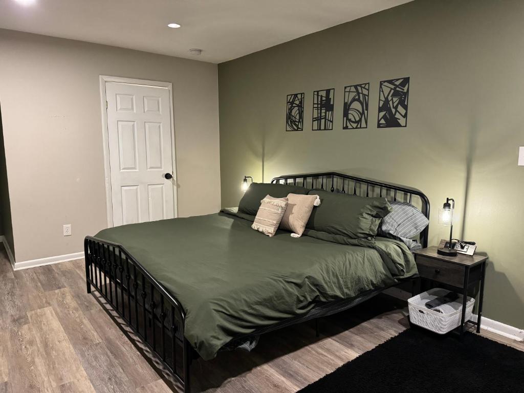 una camera da letto con un letto con un piumone verde di King Suite - Private Entrance - Hot Tub - Game Room a Jonesboro