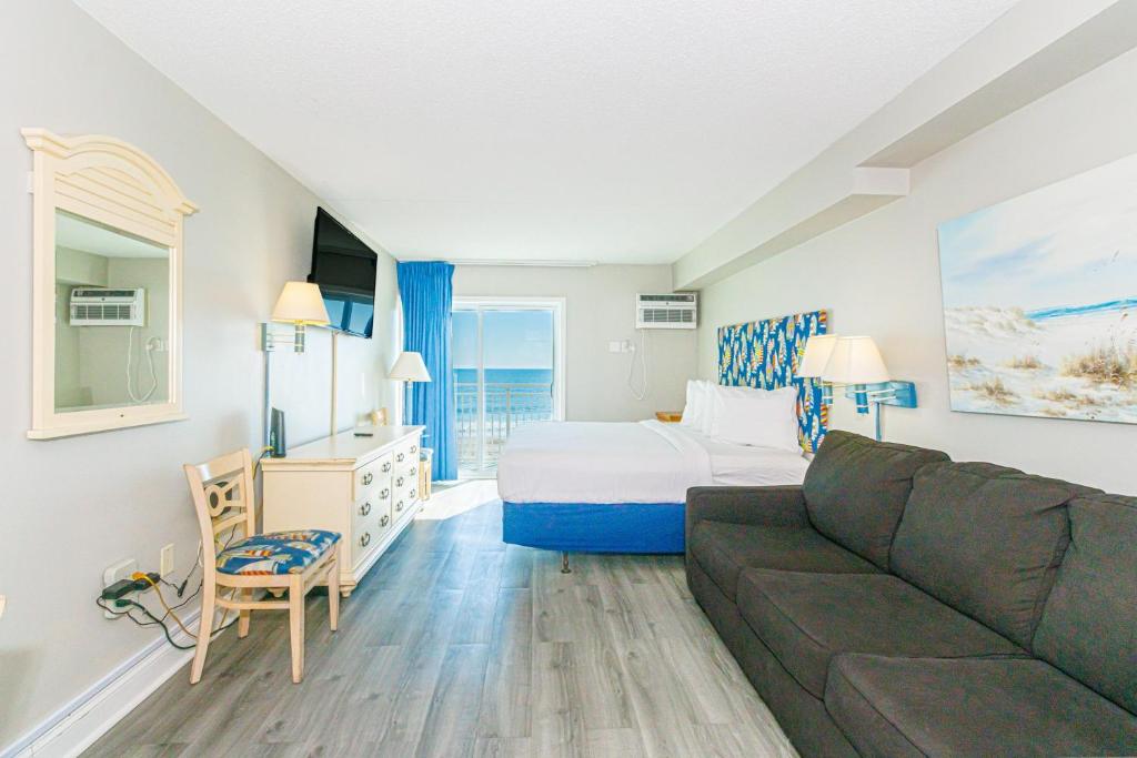 une chambre d'hôtel avec un lit et un canapé dans l'établissement Breath-taking Remodeled Oceanfront Studio! Sea Mist 20307, à Myrtle Beach