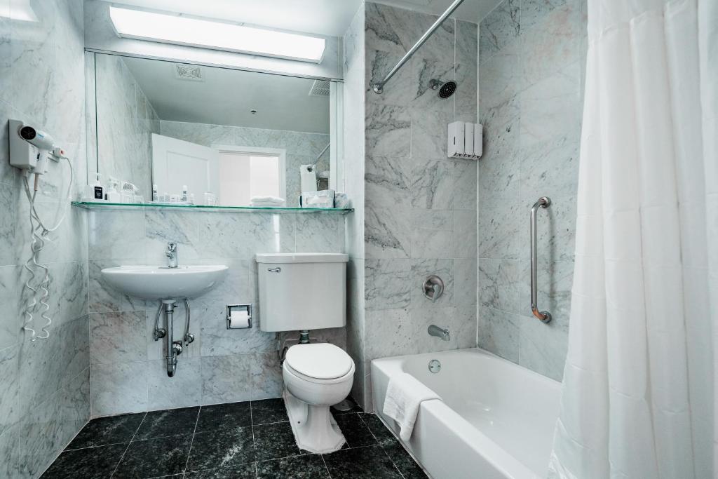 a bathroom with a sink and a toilet and a bath tub at Congress Plaza Hotel Chicago in Chicago