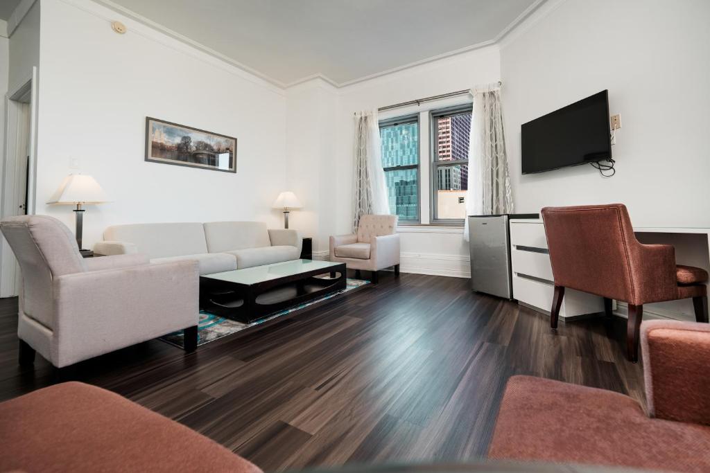 a living room with white furniture and a flat screen tv at Congress Plaza Hotel Chicago in Chicago