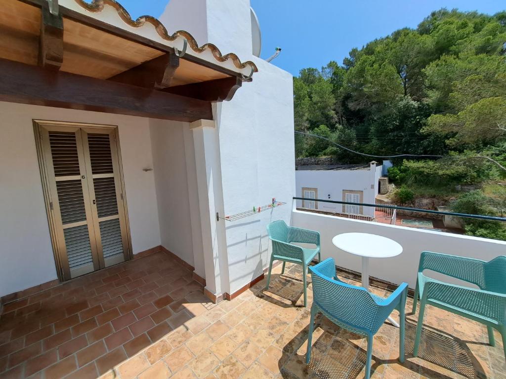 a patio with chairs and a table on a balcony at Hostal Playa in Cala Santanyi