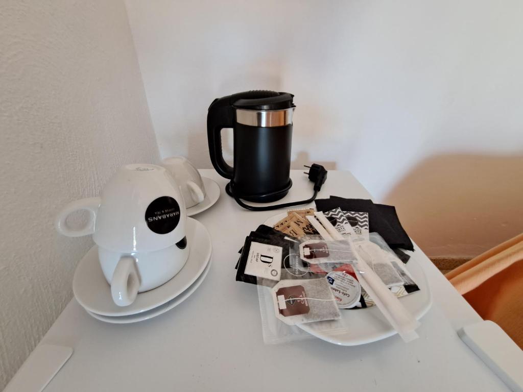 a table with a coffee maker and a tea kettle at Hostal Playa in Cala Santanyi