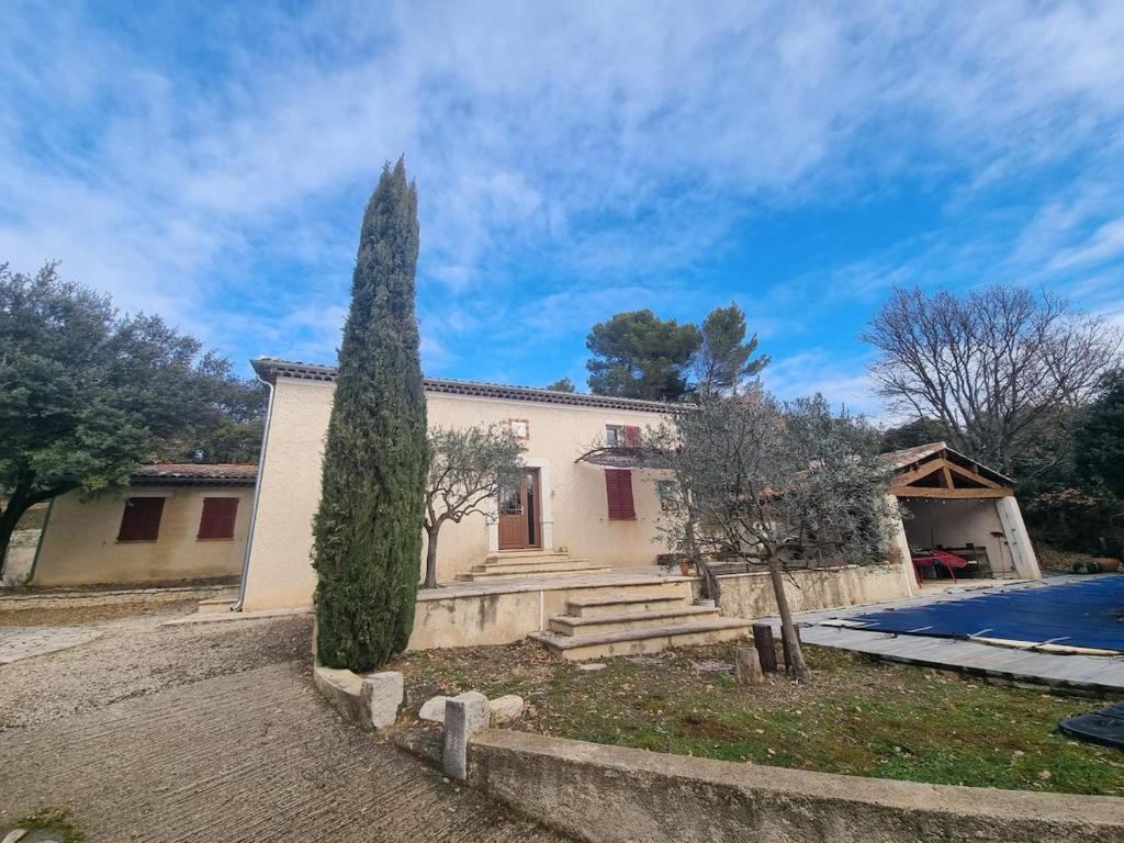 une maison avec un arbre devant dans l'établissement Ecrin de Verdure, à Baudinard