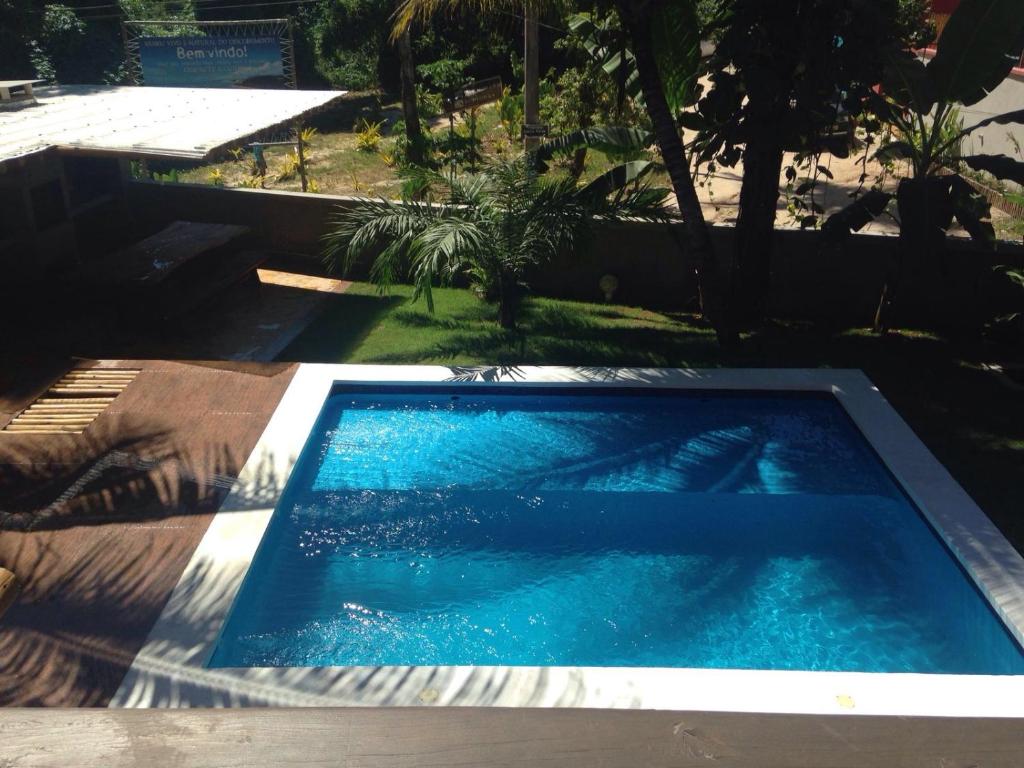 a large blue swimming pool in a yard at D'ajuda Flat in Arraial d'Ajuda