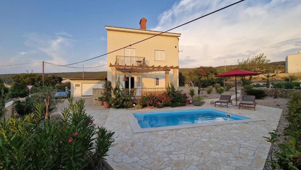 a house with a swimming pool in a yard at Kuća Koza-Apartment Marijana in Punat