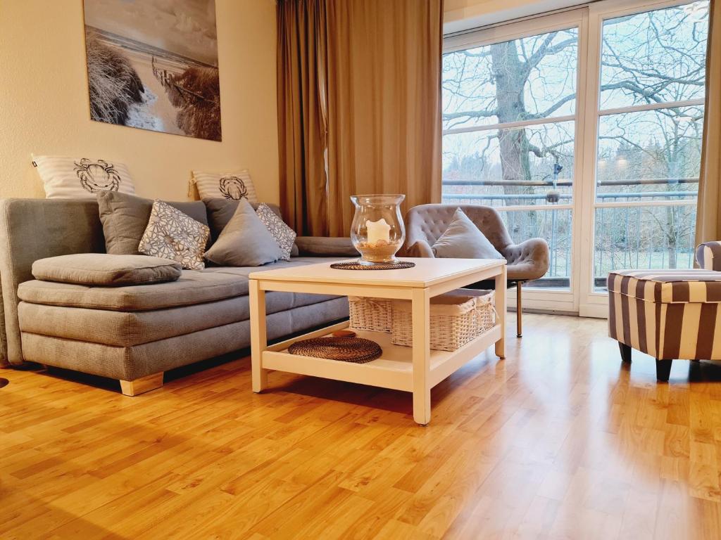 una sala de estar con un sofá y una mesa en Fewo Jara, en Kägsdorf