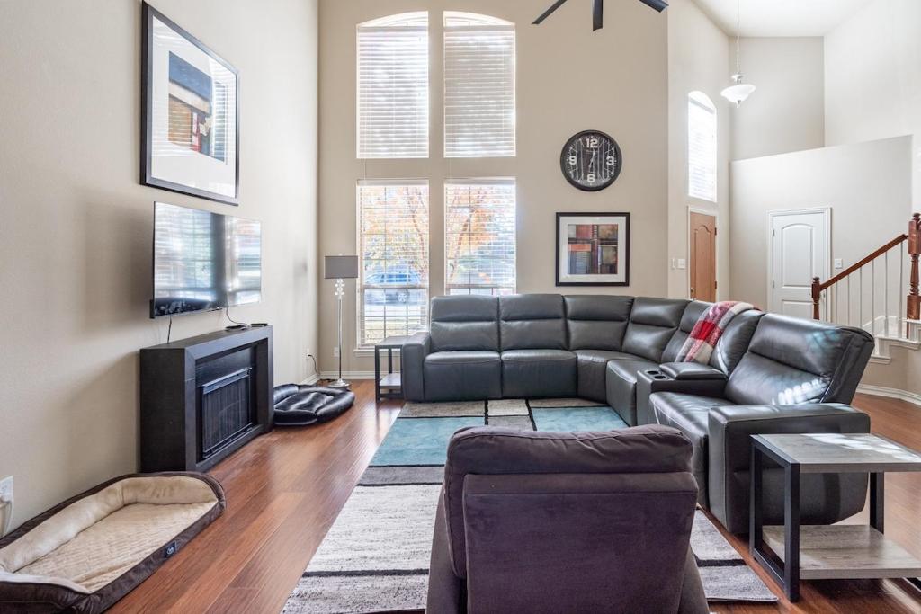 a living room with a couch and a tv at Bright and Spacious 3 Bedroom Townhome, Minutes from DFW Airport in Irving