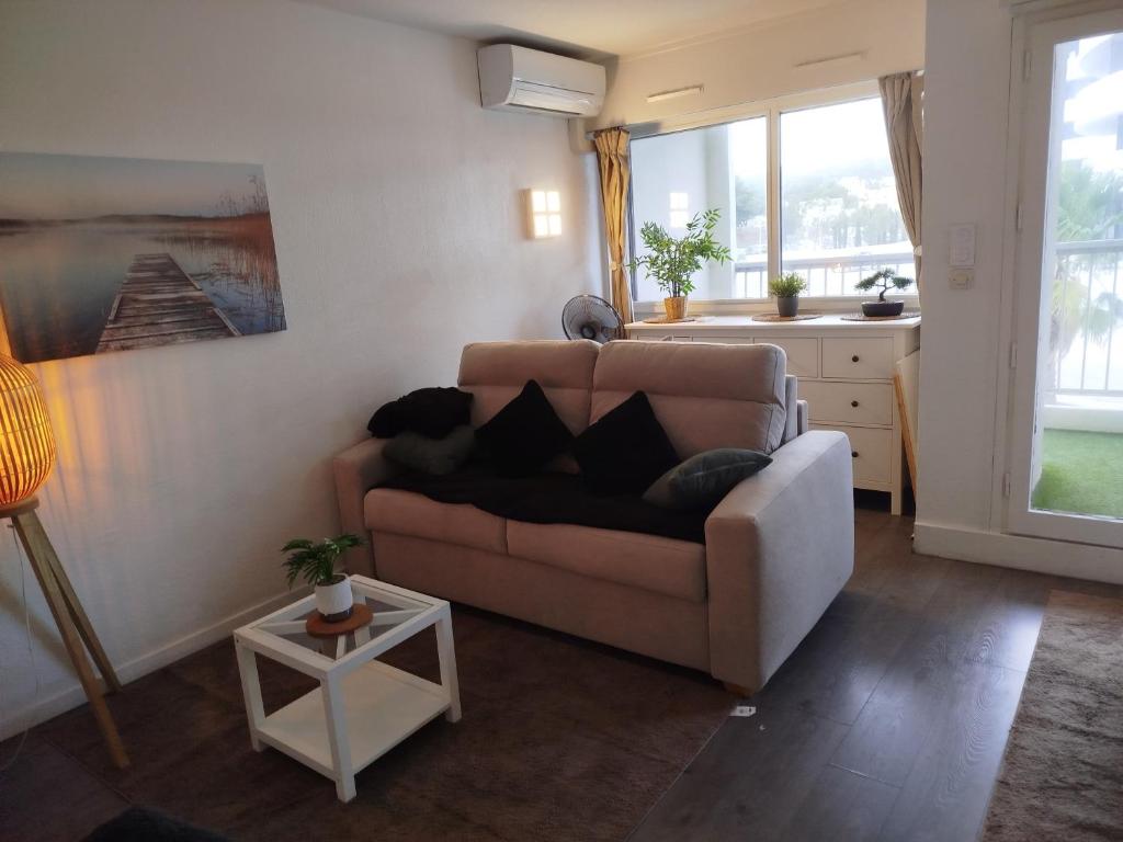 un salon avec un canapé et une table dans l'établissement Résidence Orion position centrale piscine parking privé terrasse, au Cap d'Agde