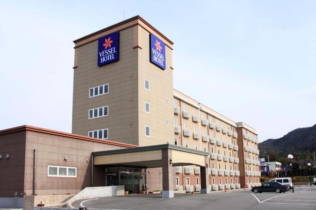 a hotel building with a sign on top of it at Vessel Hotel Higashi Hiroshima in Higashihiroshima