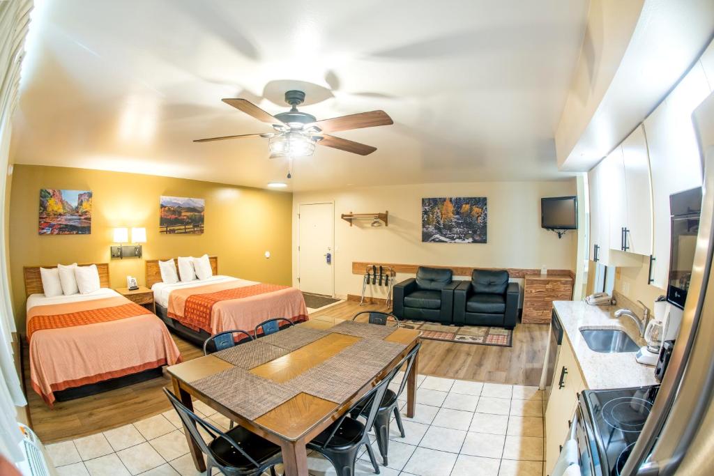 a hotel room with two beds and a table at Glenwood Springs Cedar Lodge in Glenwood Springs