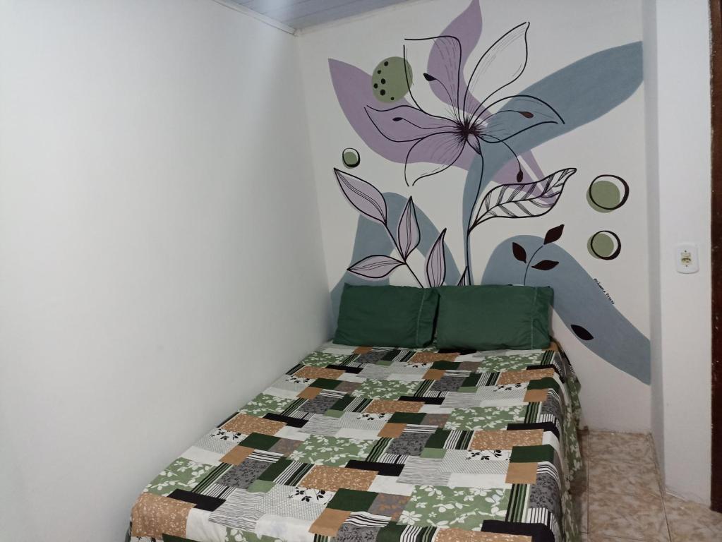 a bedroom with a bed with a flower mural on the wall at Refúgio de Piratininga 203 in Niterói
