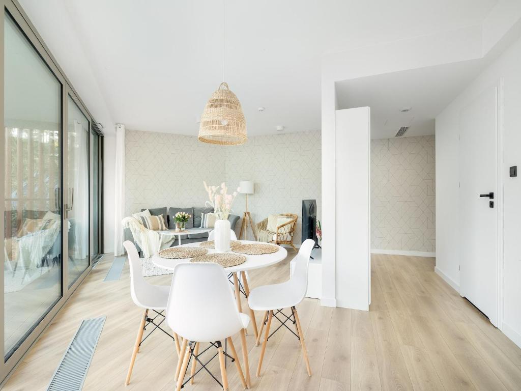 a dining room with a table and white chairs at Apartment in Pobierowo with Sea View in Pobierowo