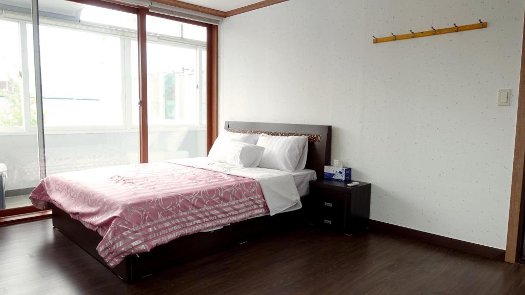 a bedroom with a bed and a large window at Happy Memory in Jeonju
