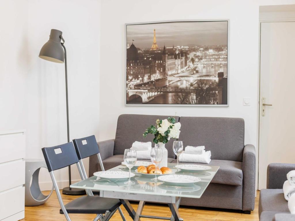 un salon avec une table et un canapé dans l'établissement Lovely studio near Eiffel Tower, à Paris