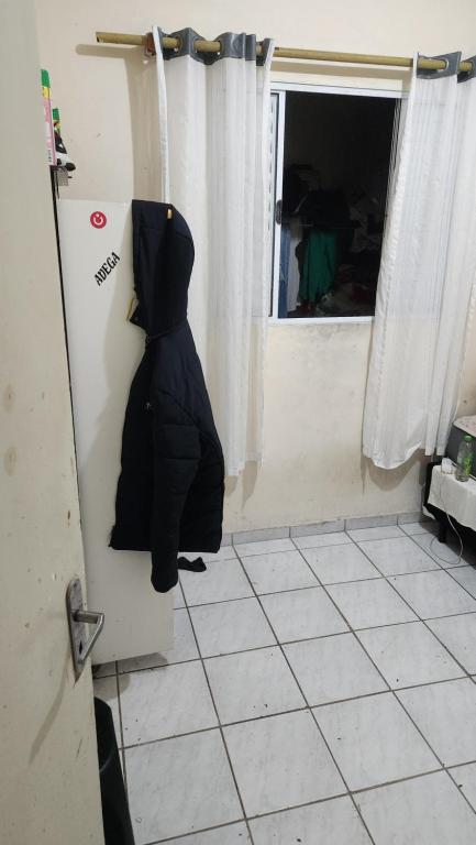 a black dog is hanging on the door of a room at Apartamento esperanza in Barueri