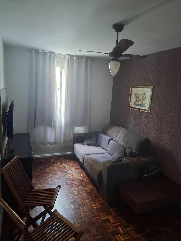 a living room with a couch and a ceiling fan at Apartamento MAR AZUL 2 in Vila Velha
