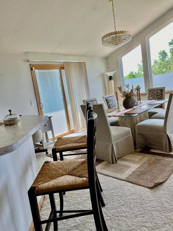 a living room with chairs and a table and windows at Mixon villas in Waterbury