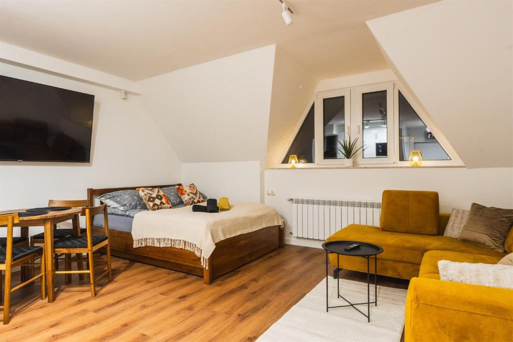 a bedroom with a bed and a table and a couch at Apartament pod Gubają in Zakopane