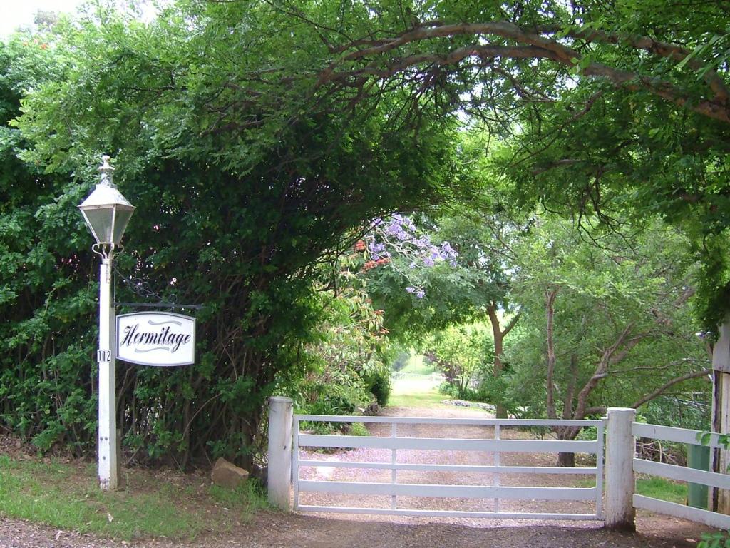 een bord op een hek naast een hek bij Hermitage Cottage in Kurrajong