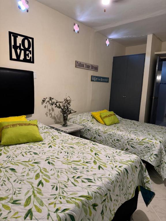 Dos camas una al lado de la otra en una habitación. en Gaia, en Medellín