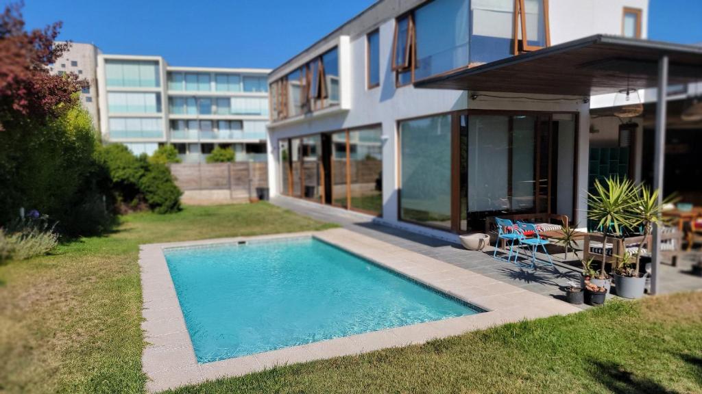 a house with a swimming pool next to a building at RbkºCasa mediterránea para 10 personas con piscina in Viña del Mar