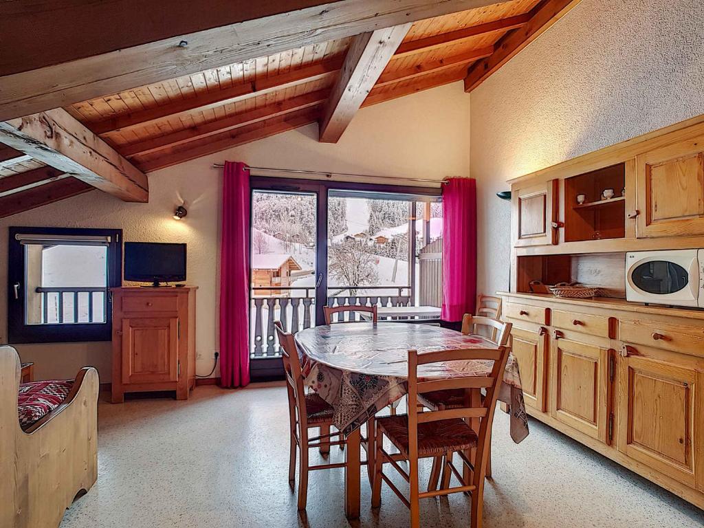 une cuisine avec une table et des chaises dans une pièce dans l'établissement Appartement 8 pers, La Clusaz, parking, animaux bienvenus - FR-1-818-5, à La Clusaz