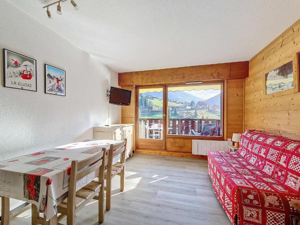 un salon avec un canapé rouge et une table dans l'établissement Studio cosy à La Clusaz pour 4 pers, WIFI, garage, animaux admis - FR-1-818-3, à La Clusaz