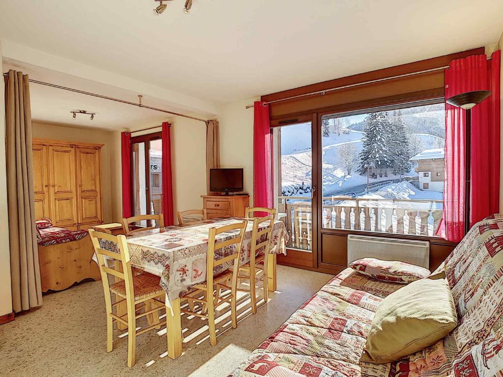 Cette chambre dispose d'une table, de chaises et d'un balcon. dans l'établissement La Clusaz : Appartement 6 pers, Wifi, Animaux OK, Parking - FR-1-818-35, à La Clusaz
