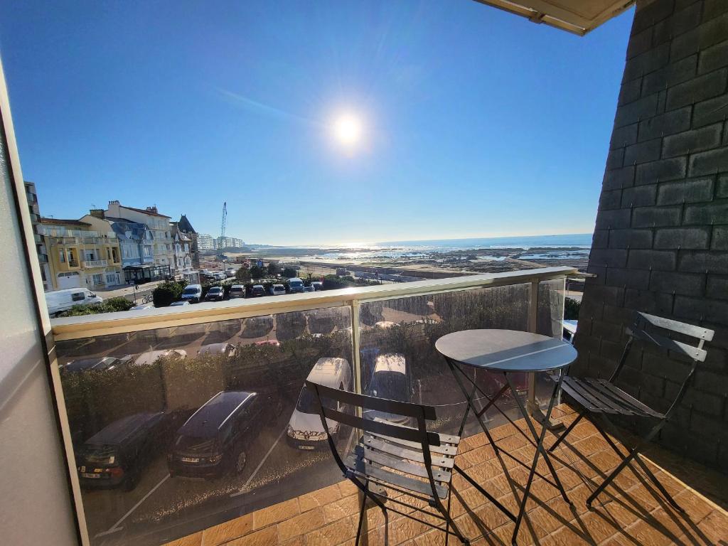 un balcon avec une table et des chaises et une vue dans l'établissement Studio neuf proche plage et commerces, balcon vue mer - FR-1-92-945, à Les Sables-dʼOlonne