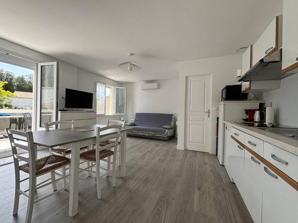 une cuisine et une salle à manger avec une table et des chaises dans l'établissement Saint-Palais : T2 3 étoiles, proche plage, terrasse sud, parking, clim et Wifi - FR-1-738-36, à Saint-Palais-sur-Mer