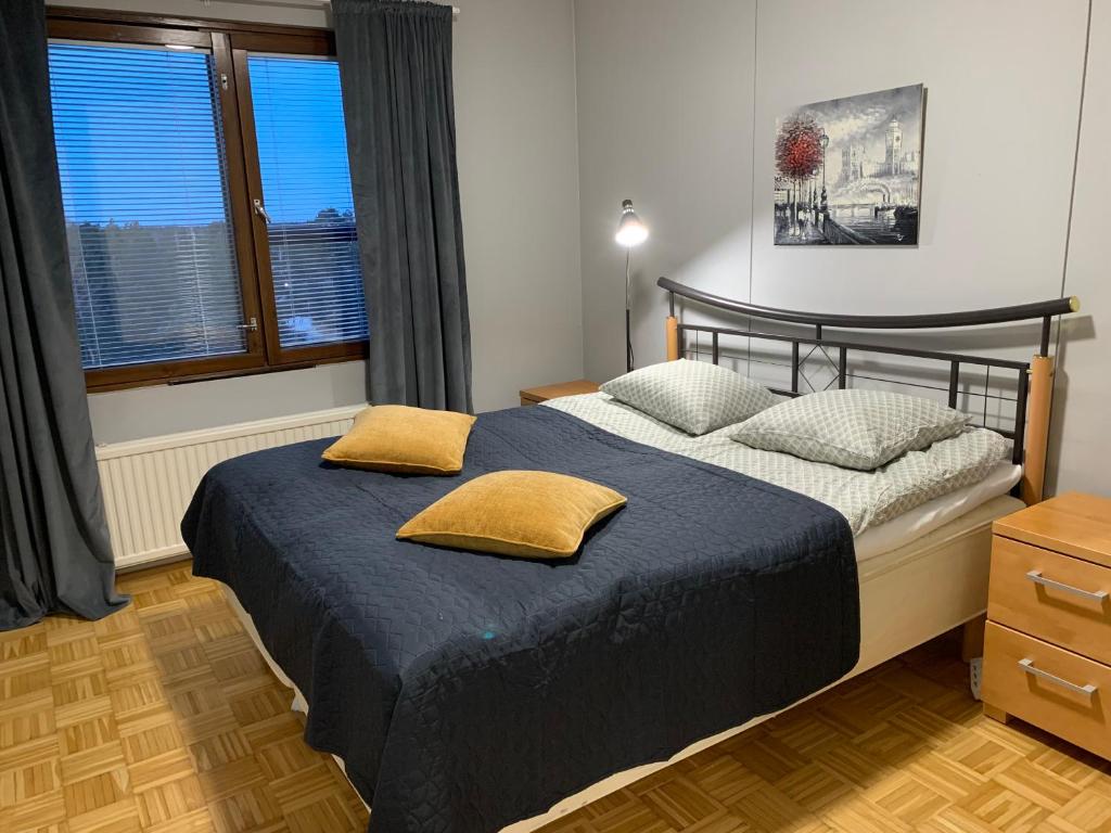 a bedroom with a bed with two pillows on it at Cozy 2BR Apartment KA64 with sauna in Oulu