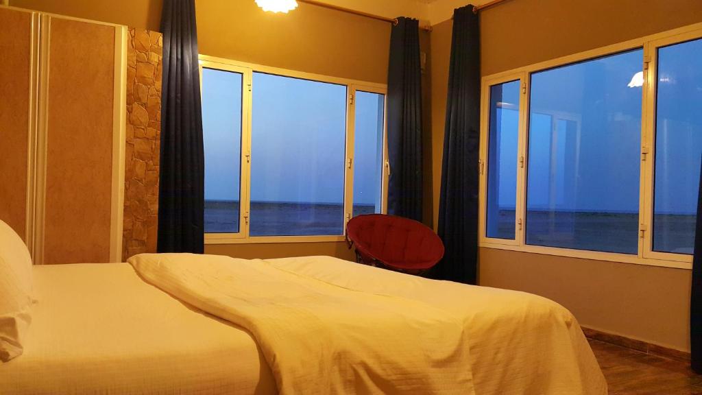 a bedroom with a bed and a view of the ocean at Masirah Beach camp in Al Qārin