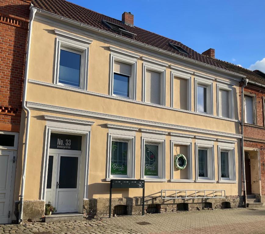 a building with white windows on a street at B&K Immobilien GbR in Tangermünde