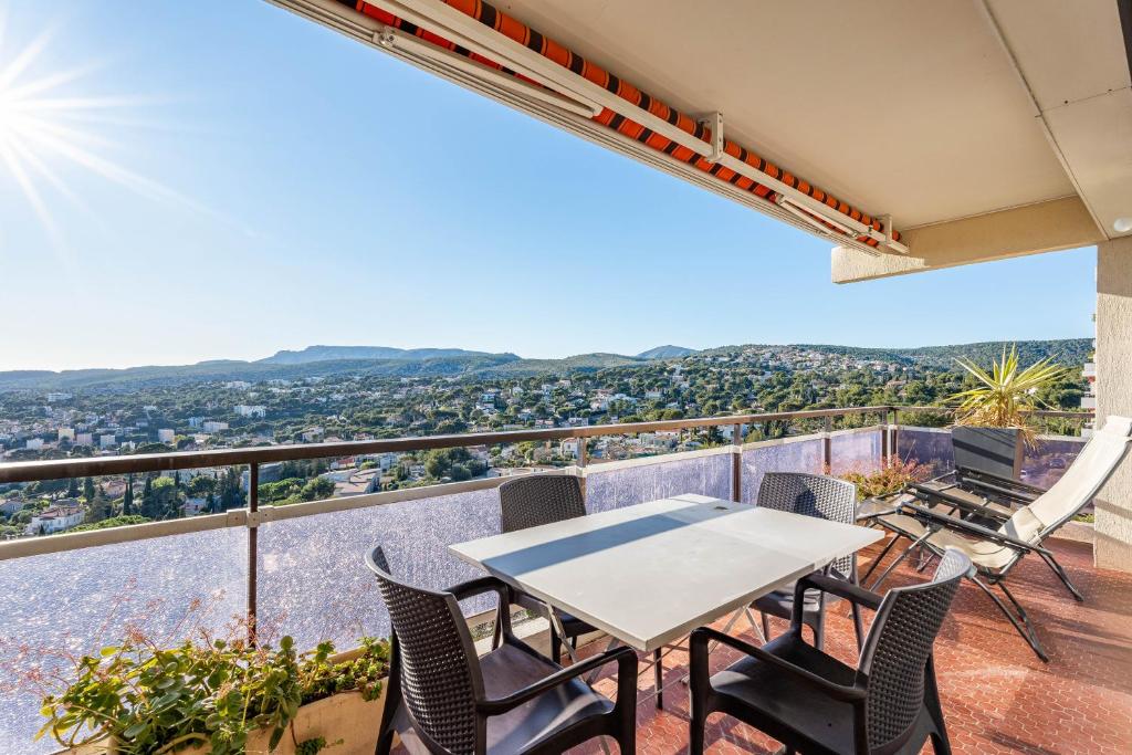 un patio avec une table et des chaises sur un balcon dans l'établissement Les 3 Caravelles par Dodo à Cassis, à Cassis